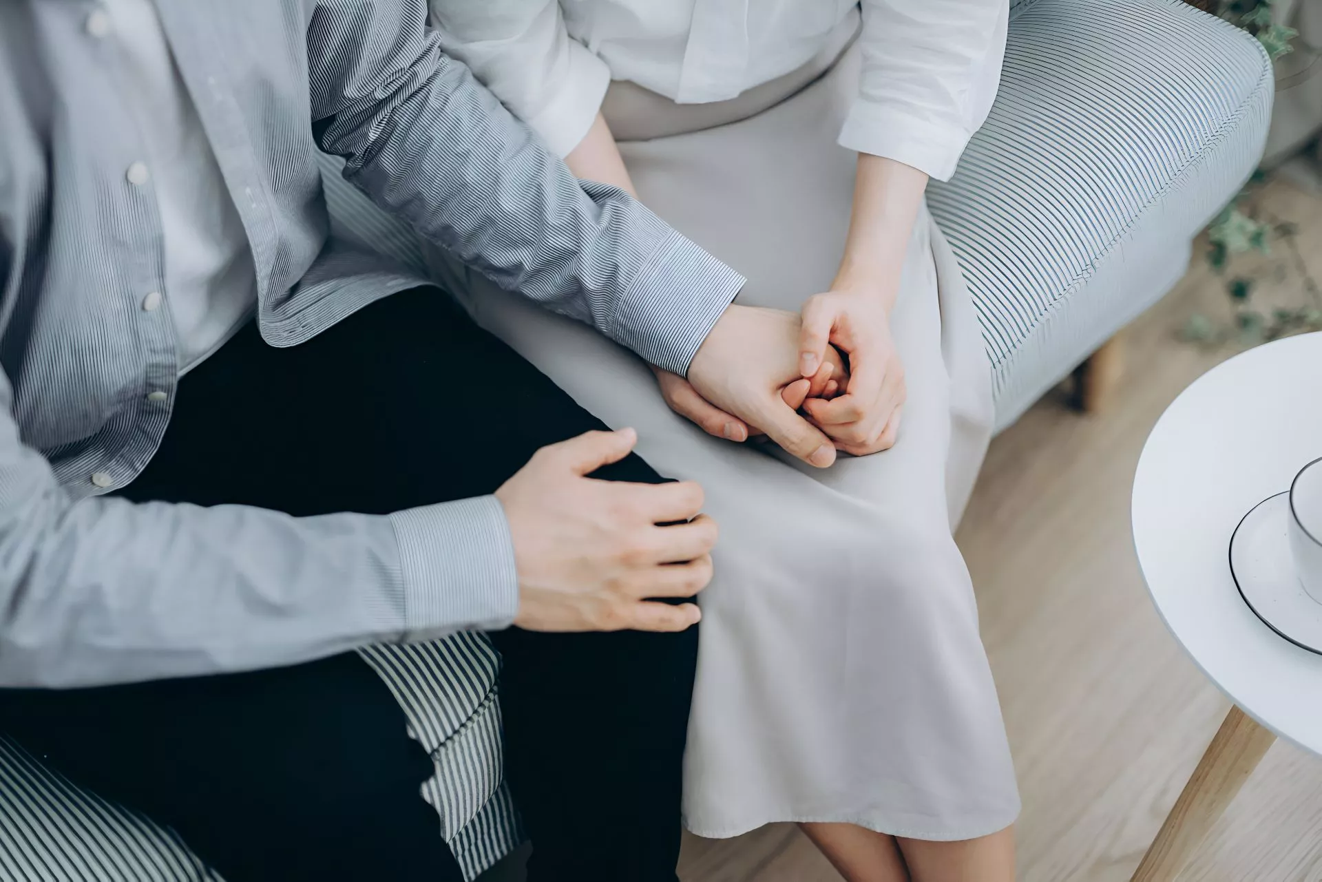 溫柔情境照，一對男女坐在沙發上牽手互動，呈現成熟穩定的包養關係氛圍與互惠陪伴感，強調尊重與安全界線的情緒連結。